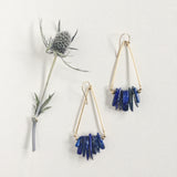Axis Earrings by Third & Co. Studio: Lapis shards in blue and cream, triangular shape raw brass frames, and 14k gold filled ear wires, shown against a white background with dried thistle floral