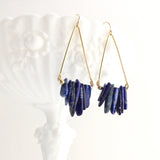 Axis Earrings by Third & Co. Studio: Lapis shards in blue and cream, triangular shape raw brass frames, and 14k gold filled ear wires, shown hanging from a white dish against a white background