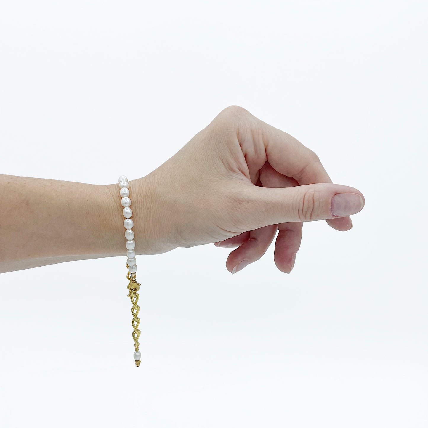 model wearing the Aletta Bracelet from Third & Co. Studio with white fresh water pearl, gold plated vintage chain with adjustable length on the wrist against a white background