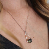 model wearing a Labradorite round in green gray with flashing blue, sterling silver elongated triangle shape, sterling silver chain short necklace