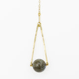 Round Labradorite in green, gray and flashes of blue with an elongated triangular hammered brass frame, a small vintage bar accent and 14K gold fill chain 30" length necklace