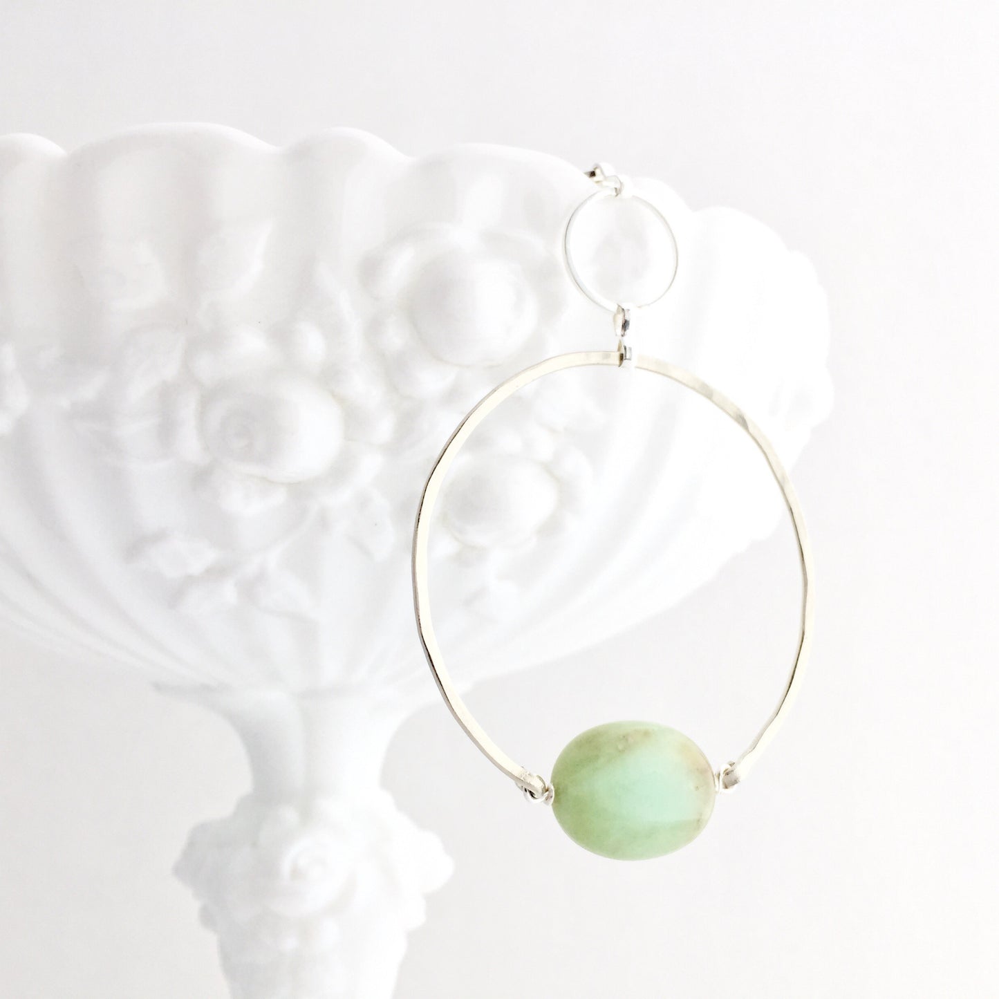 Apogee Necklace by Third & Co. Studio; light green and brown Chrysophase flat oval, vintage silver circle & oval chain, silver plated nickel-free chain, hammered German silver nickel circle, shown closeup draped on a white dish and white background