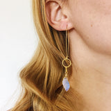 model wearing the Aurora Earrings by Third & Co. Studio: faceted synthetic wavy-shaped Opalite in clear and blue flashing rainbow colors, small sections of gold plated vintage circle geometric chain, gold-plated stainless steel ear wires, lightweight sparkly statement earrings