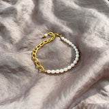 Aletta Bracelet from Third & Co. Studio with white fresh water pearl, gold plated vintage chain with adjustable length sitting in the sun on silky gray fabric