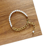 Aletta Bracelet from Third & Co. Studio with white fresh water pearl, gold plated vintage chain with adjustable length on wood with a white background