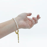 model wearing the Aletta Bracelet from Third & Co. Studio with white fresh water pearl, gold plated vintage chain with adjustable length on the wrist against a white background