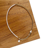 The Aletta Necklace by Third & Co. Studio: fresh water pearl, vintage gold-toned chain, mother of pearl and labradorite, create this adjustable length, wear-two-ways necklace. Can also be worn as a bracelet by wrapping around the wrist. Necklace shown against wood and a white background