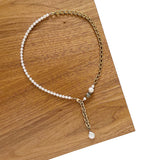 The Aletta Necklace by Third & Co. Studio: fresh water pearl, vintage gold-toned chain, mother of pearl and labradorite, create this adjustable length, wear-two-ways necklace. Can also be worn as a bracelet by wrapping around the wrist. Necklace shown at the shortest adjustable lariat length, against a wood and white background