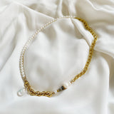 The Aletta Necklace by Third & Co. Studio: fresh water pearl, vintage gold-toned chain, mother of pearl and labradorite, create this adjustable length, wear-two-ways necklace. Can also be worn as a bracelet by wrapping around the wrist. Necklace shown at its longest adjustable length against a silky white fabric background