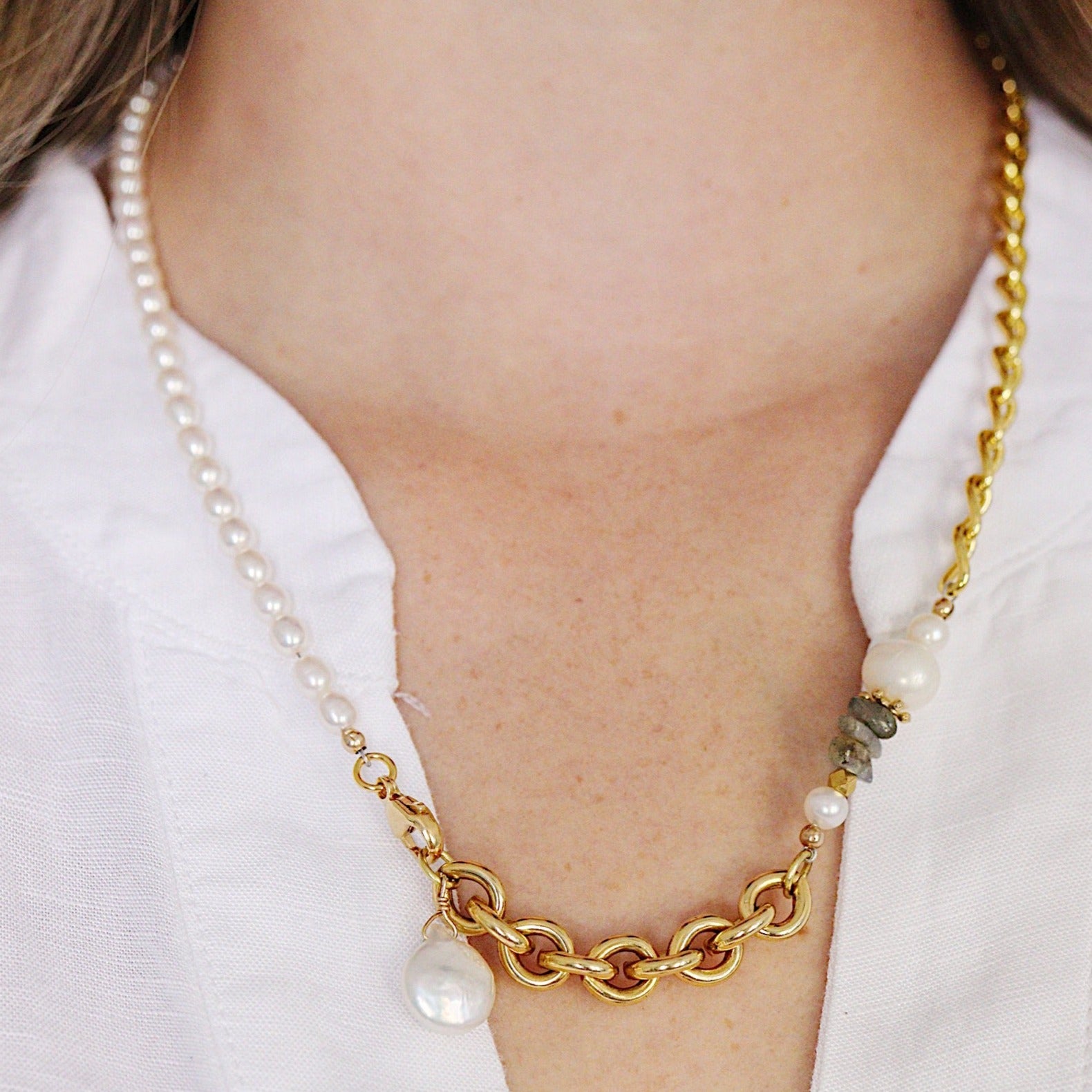 The Aletta Necklace by Third & Co. Studio: fresh water pearl, vintage gold-toned chain, mother of pearl and labradorite, create this adjustable length, wear-two-ways necklace. Can also be worn as a bracelet by wrapping around the wrist. Necklace shown on a model wearing a white top, at the longest adjustable length