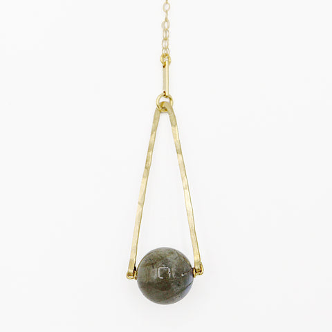 Round Labradorite in green, gray and flashes of blue with an elongated triangular hammered brass frame, a small vintage bar accent and 14K gold fill chain 30" length necklace