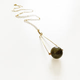 Round Labradorite in green, gray and flashes of blue with an elongated triangular hammered brass frame, a small vintage bar accent and 14K gold fill chain 30" length necklace on white background